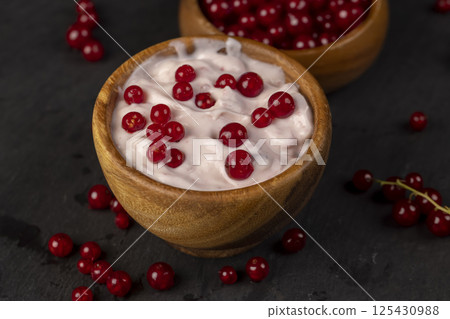 milk product made from milk with the addition of red sweet and sour currants and currant flavor, side view milk product made from milk with the addition of red sweet and sour currants and currant flavor, side view 125430988