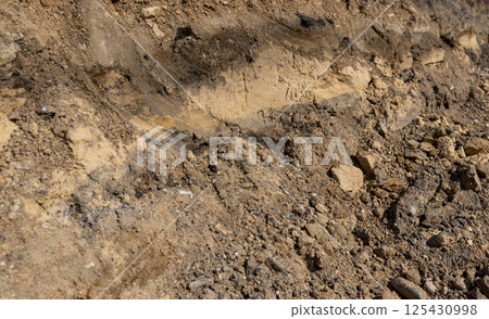 the end of summer at the construction site, dry sand and earth in sunny weather, side view the end of summer at the construction site, dry sand and earth in sunny weather, side view 125430998