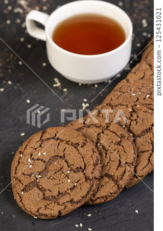 chocolate biscuits on the kitchen table, chocolate biscuits with real cocoa and sesame seeds 125431021