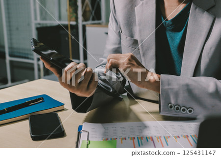 Working from home, Closeup business woman using laptop computer and analyzing financial report. 125431147