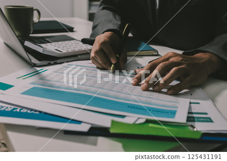 Working from home, Closeup business woman using laptop computer and analyzing financial report. 125431191