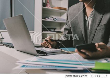 Working from home, Closeup business woman using laptop computer and analyzing financial report. Working from home, Closeup business woman using laptop computer and analyzing financial report. 125431194