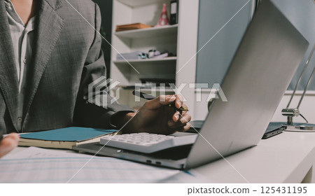 Working from home, Closeup business woman using laptop computer and analyzing financial report. Working from home, Closeup business woman using laptop computer and analyzing financial report. 125431195