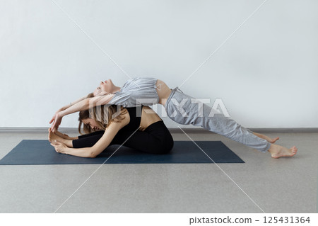 sporty yogi sisters doing fitness training. pair, couple yoga sporty yogi sisters doing fitness training. pair, couple yoga 125431364
