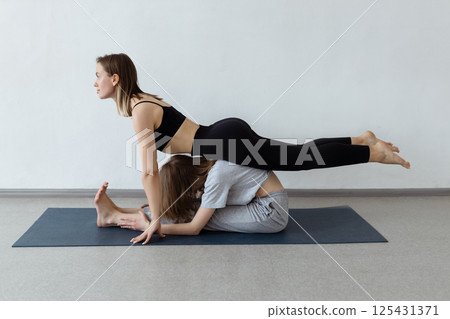 sporty yogi sisters doing fitness training. pair, couple yoga sporty yogi sisters doing fitness training. pair, couple yoga 125431371