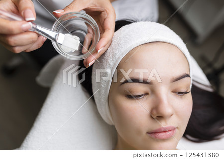 Close-up shot of a woman getting facial treatment with clay mask. Cosmetology and spa Close-up shot of a woman getting facial treatment with clay mask. Cosmetology and spa 125431380
