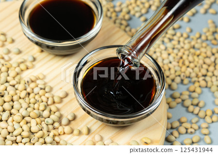 Stream of Soy Sauce Filling a Sauce Dish Stream of Soy Sauce Filling a Sauce Dish 125431944