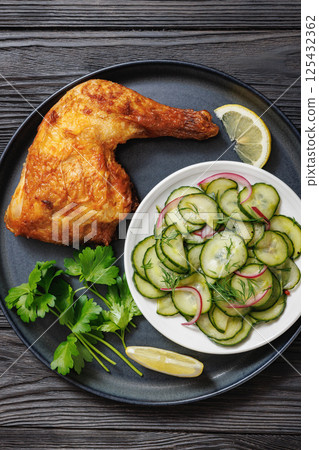 roast chicken leg with salad on a plate 125432362