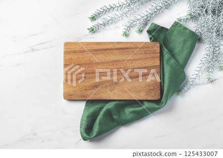 Wood plate board with green kitchen cloth on marble table 125433007
