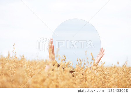 Hands and Mirror in Golden Field 125433038