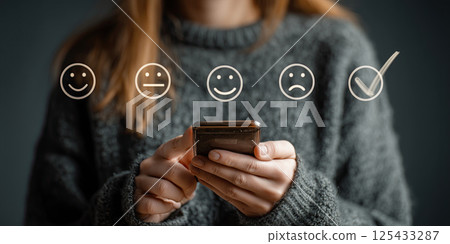 person using smartphone to complete online survey with emoticon options person using smartphone to complete online survey with emoticon options 125433287