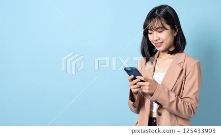 A young woman looking at a smartphone 125433903