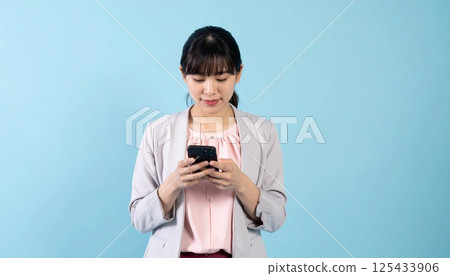 A young woman looking at a smartphone 125433906