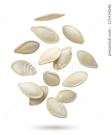 Pumpkin seeds flying close-up on a white. Isolated 125434046