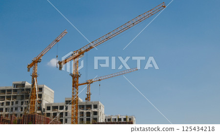 construction site under development with cranes with blue sky background construction site under development with cranes with blue sky background 125434218