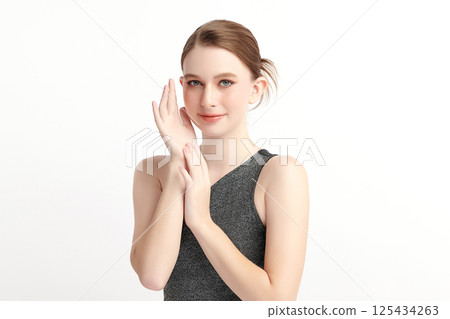 A beautiful young woman with clean, fresh skin against a white background. Skincare, facial treatment, cosmetology, beauty, and spa. An elegant portrait of an woman. 125434263