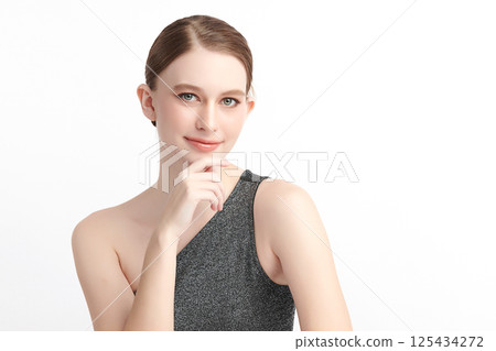 A beautiful young woman with clean, fresh skin against a white background. Skincare, facial treatment, cosmetology, beauty, and spa. An elegant portrait of an woman. 125434272