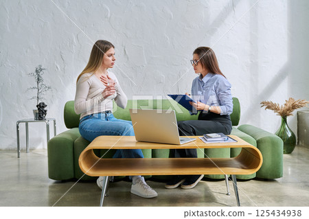 Serious young woman in session in office of professional psychologist, therapist 125434938