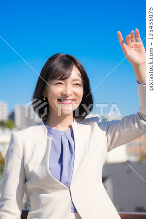藍天下,一位自信的中年職業女性,身穿白色西裝 藍天下,一位自信的中年職業女性,身穿白色西裝 125435076