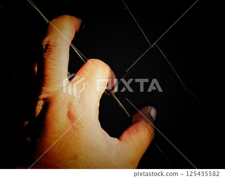 Hands holding a cage, a concept of being locked up and without freedom, a prisoner who is sentenced to prison. 125435582