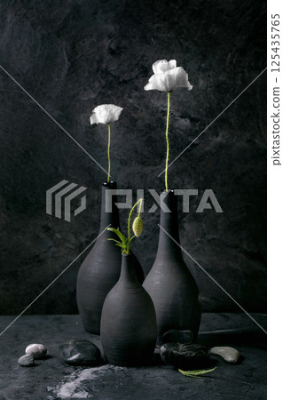 White Poppies in Black Ceramic Vases 125435765