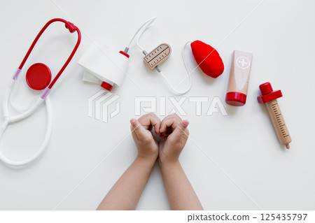 Child hands with toy medical tools on white background 125435797