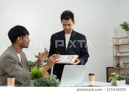 Business Presentation and Analysis. A professional presenting data insights during a meeting. 125436030