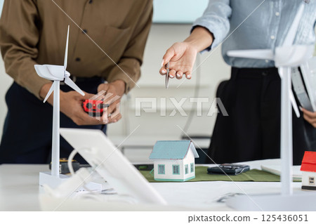 Sustainable Design and Collaboration. Professionals engaging in a planning session for eco-friendly housing. Sustainable Design and Collaboration. Professionals engaging in a planning session for eco-friendly housing. 125436051