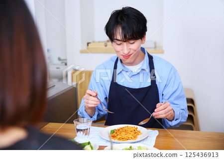 Image of a couple eating pasta made by the husband 125436913