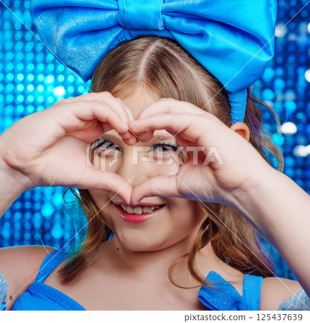 close up. Cute teenage girl in blue doll dress with big blue bow posing. close up. Cute teenage girl in blue doll dress with big blue bow posing. 125437639