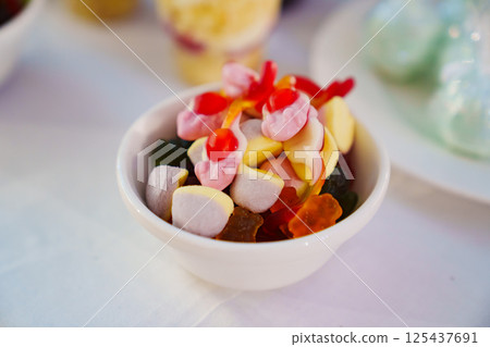 A small bowl with colorful gummies.  125437691