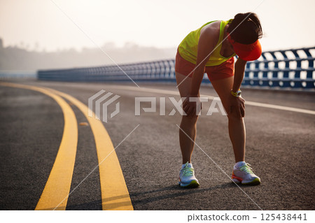 Fitness woman runner running on seaside bridge 125438441