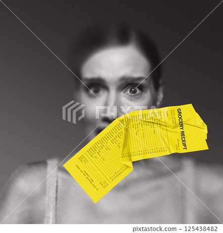 Scared woman with yellow grocery receipt taped over mouth symbolizing consumer shock from skyrocketing prices. Conceptual design. Scared woman with yellow grocery receipt taped over mouth symbolizing consumer shock from skyrocketing prices. Conceptual design. 125438482