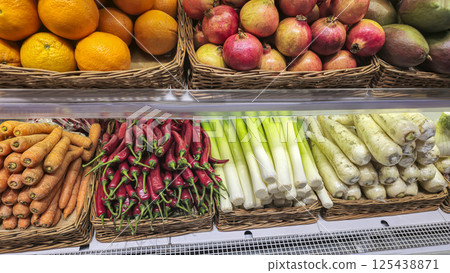 Carrots chili peppers and daikon oranges and pomegranates stacked on the counter Carrots chili peppers and daikon oranges and pomegranates stacked on the counter 125438871