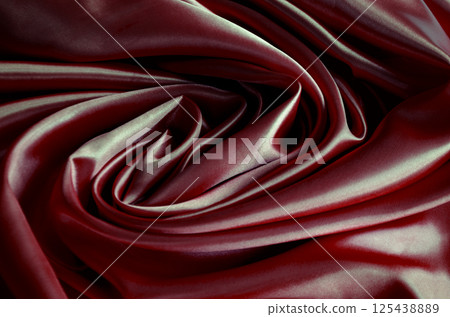 Top view of polished dark red silk cloth with silky sheen and beautiful natural draping. Suitable for design and wallpaper background 125438889