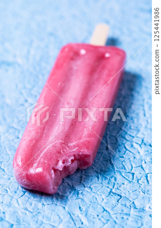 Red strawberry popsicles on blue background. 125441986