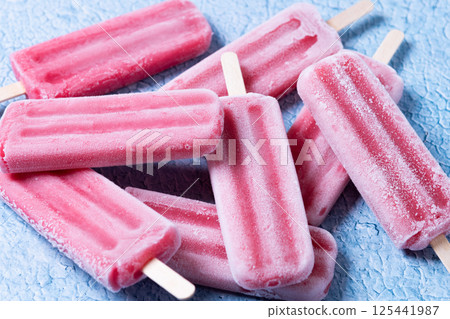Red strawberry popsicles on blue background. 125441987