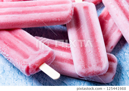 Red strawberry popsicles on blue background. 125441988
