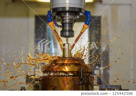 Close up scene the CNC milling machine finishing cut the brass shell mold parts with oil coolant method. 125442506