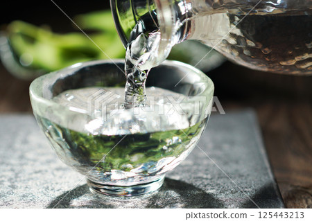 Sake and edamame being poured 125443213