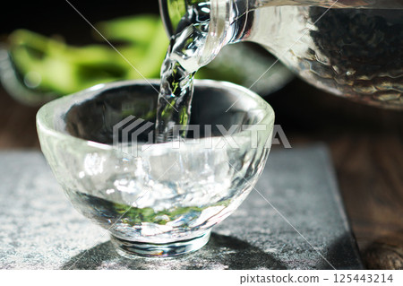Sake and edamame being poured 125443214