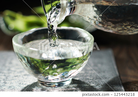 Sake and edamame being poured 125443218