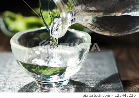 Sake and edamame being poured 125443220