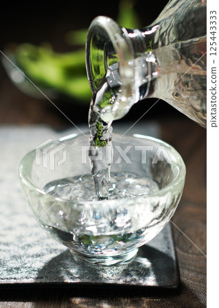 Sake and edamame being poured 125443333