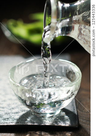 Sake and edamame being poured 125443336