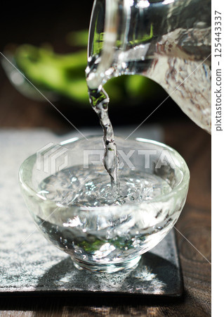 Sake and edamame being poured Sake and edamame being poured 125443337