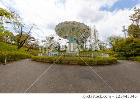 Amusement park attraction [Spinning swing] A playground equipment with a swing that spins around 125443346