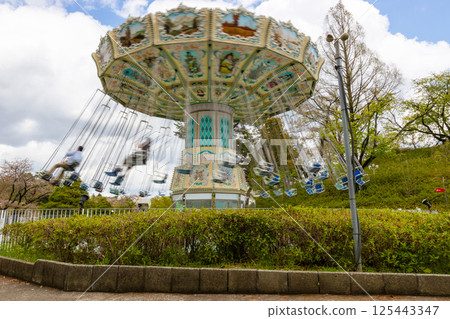 Amusement park attraction [Spinning swing] A playground equipment with a swing that spins around 125443347