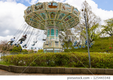 Amusement park attraction [Spinning swing] A playground equipment with a swing that spins around 125443348