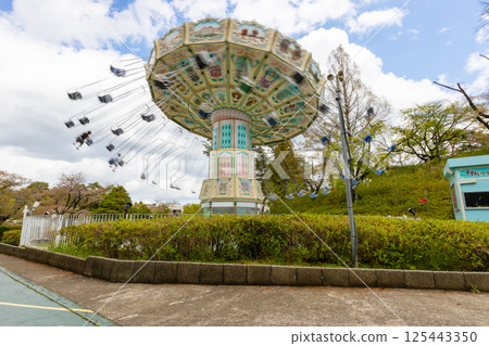 Amusement park attraction [Spinning swing] A playground equipment with a swing that spins around 125443350